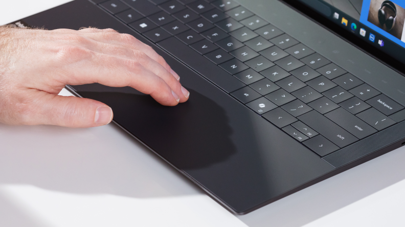 a man's hand gliding across the xps 14 trackpad