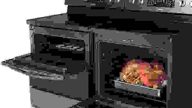 Black oven with turkey inside of it