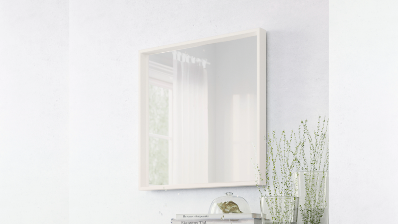 A square mirror hung on a wall.