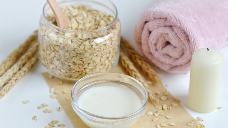 Colloidal oatmeal in a jar next to other bath supplies
