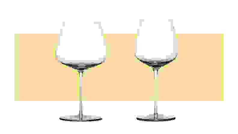 Two differently sized red wine glasses sit side by side on a yellow background.