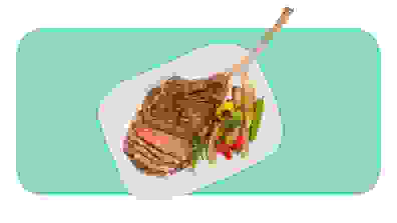 Bone-in steak served on a plate with veggies.
