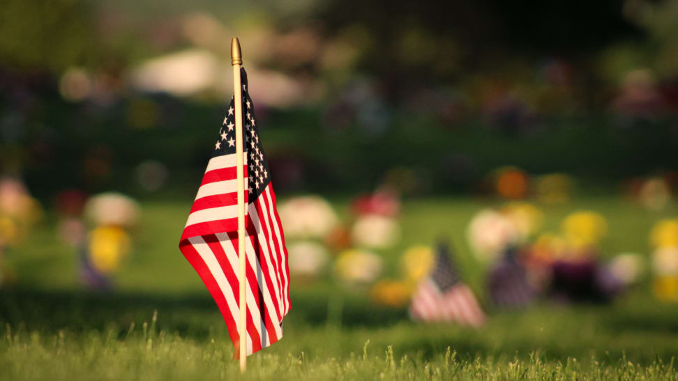 Small American flag in the ground in focus, with other flags out of focus in the background
