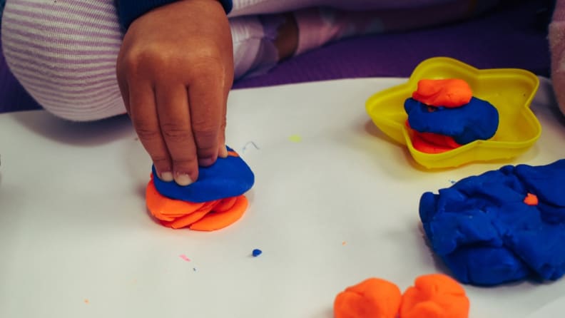 A child's hands play with Play-doh.