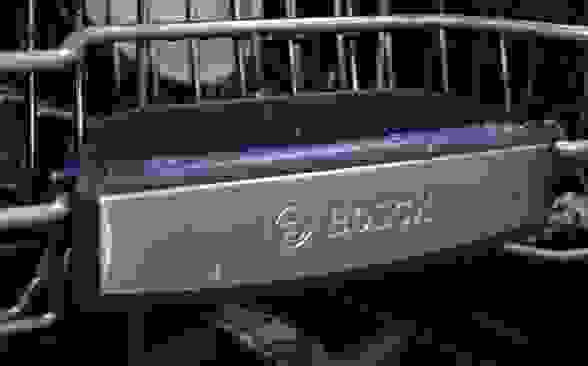 A close-up of the front of a Bosch dishwasher's top rack, which has the Bosch logo on it.