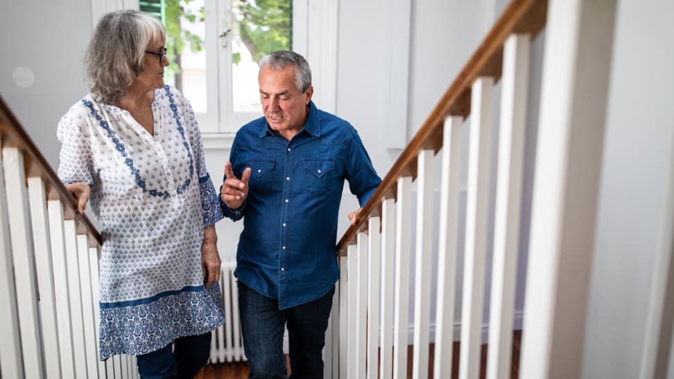 Two senior adults climb the stairs.