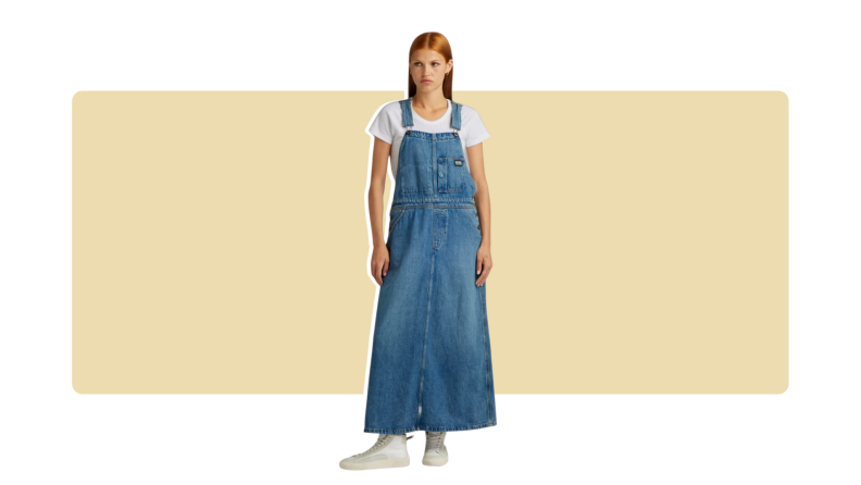 A model wearing denim skirt overalls with a white t-shirt.