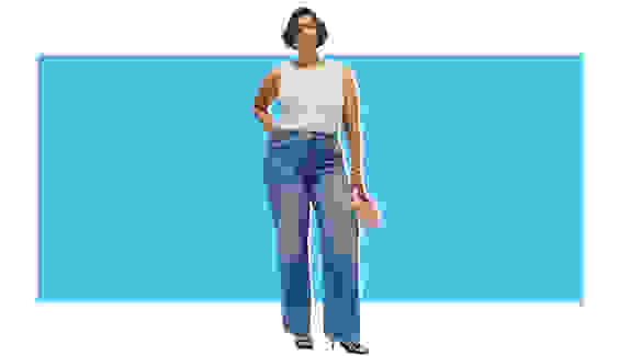 A model wearing a white tank with denim wide-leg jeans.