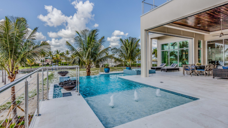 An in-ground Florida swimming pool pictured next to a home.