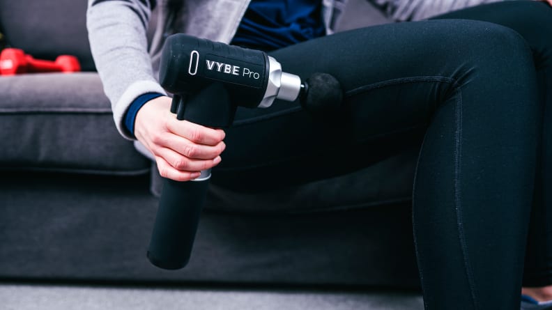 A woman using the Vybe Pro massage gun.