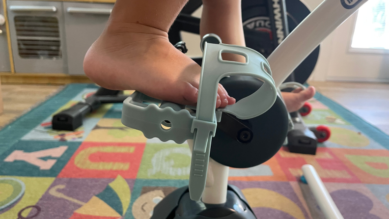 An up close shot of a toddler's foot on the pedals of the Little Tikes Pelican Bike.