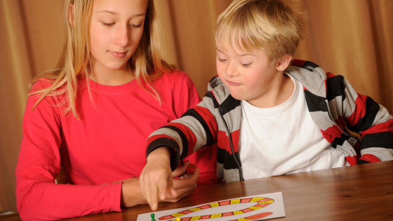 Siblings enjoying board game together.