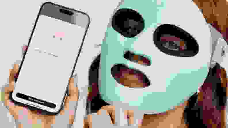 Woman wears Qure Q-Rejuvalight Pro Mask with Qure Skincare app open