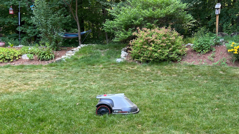 A Eufy E18 robot lawn mower sits in grass