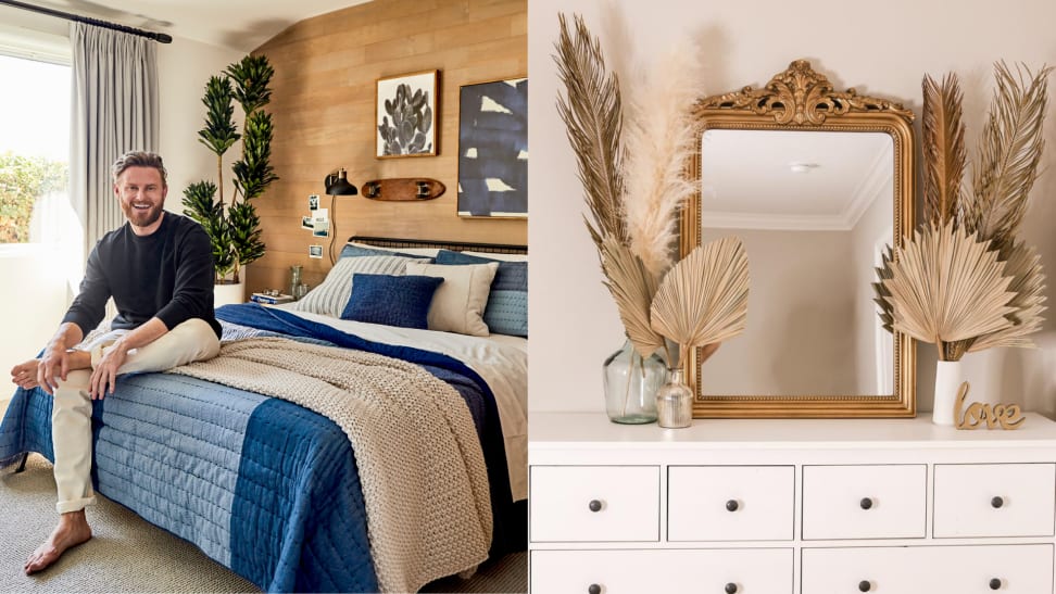 On left, Bobby Berk smiling sitting in bedroom on top of navy and cream bedspread. On right, gold mirror sitting on top white dresser next to different sized tan palm fronds.