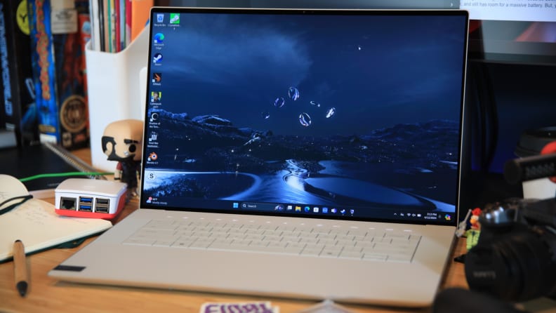 The Dell XPS 16 laptop on a desktop in white.