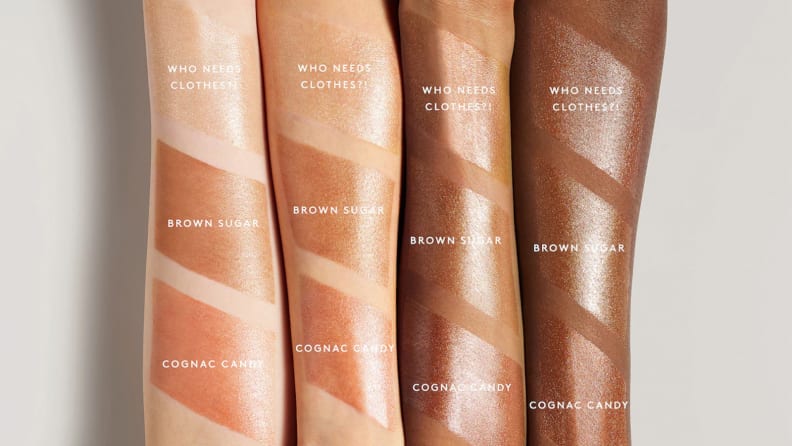 Four arms of different skin tones have swatches of the Fenty Beauty Body Lava in three different shades on them.