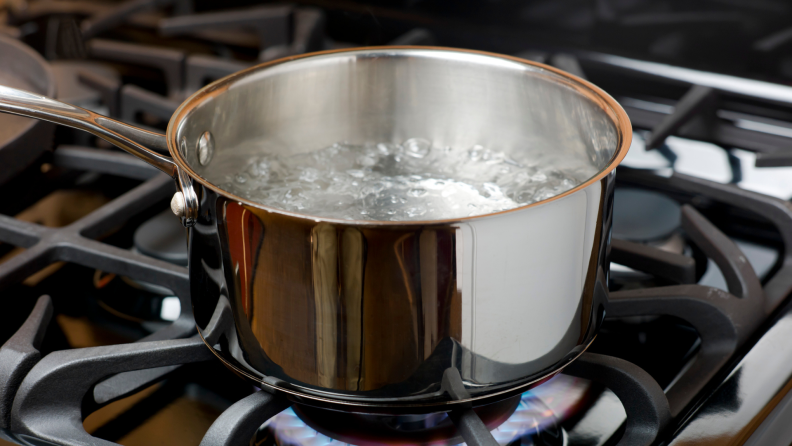 Water boiling in stainless steel pot on gas stove