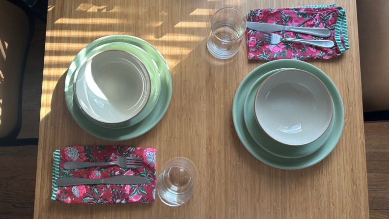 A table set with Denby pottery bowls, plates, and glasses.