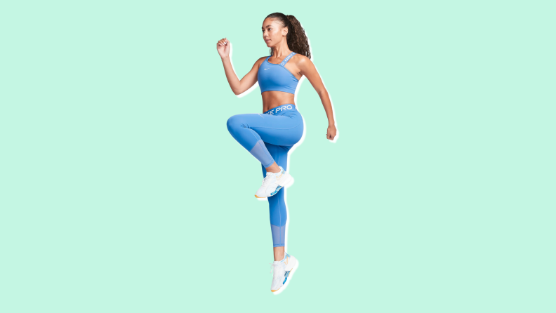 A woman doing leg lifts in blue Nike Pro Leggings.