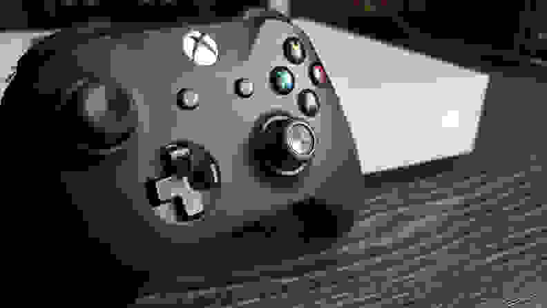 A close-up of an Xbox controller next to an Xbox console