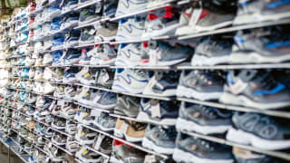 Photo of wall inside of a shoe store displaying various models of sneakers.