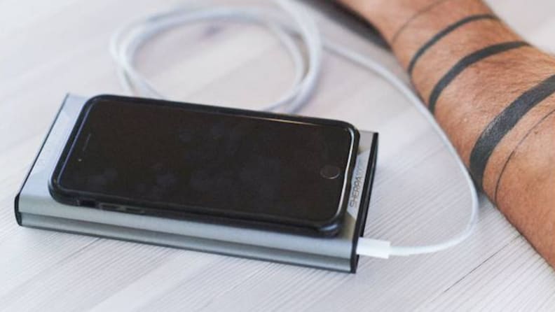 A cell phone charges on a portable charger.