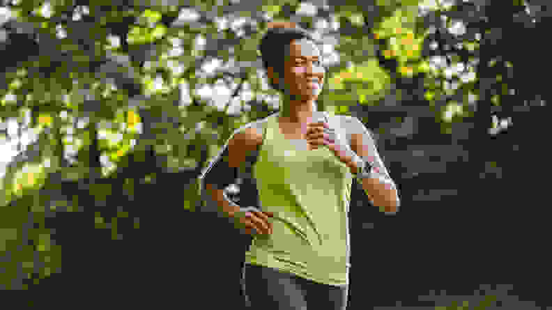 A woman running outdoors listening to music.