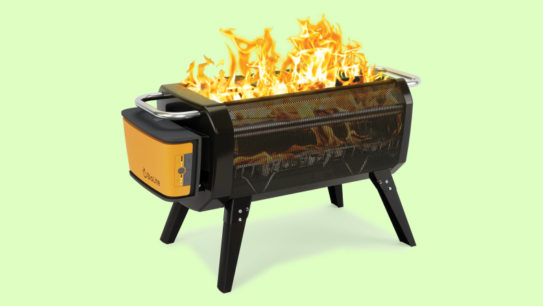A portable fire pit sits on a green background.
