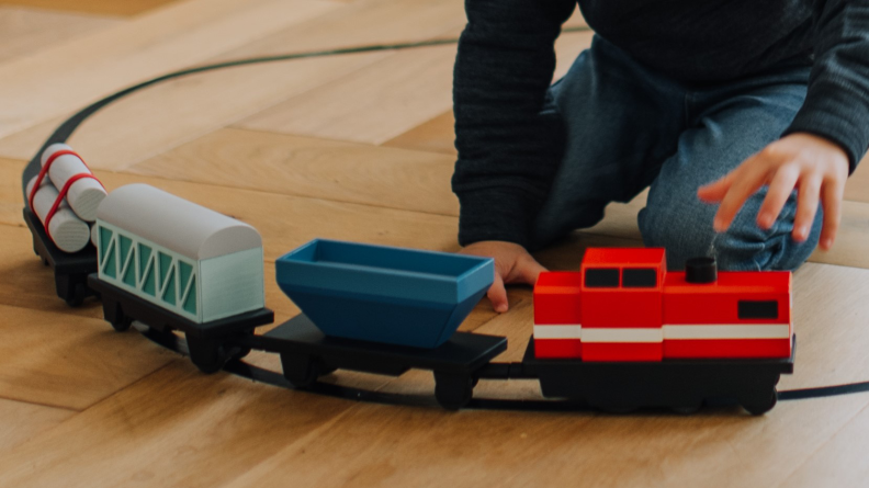 A child playing with a toy train.