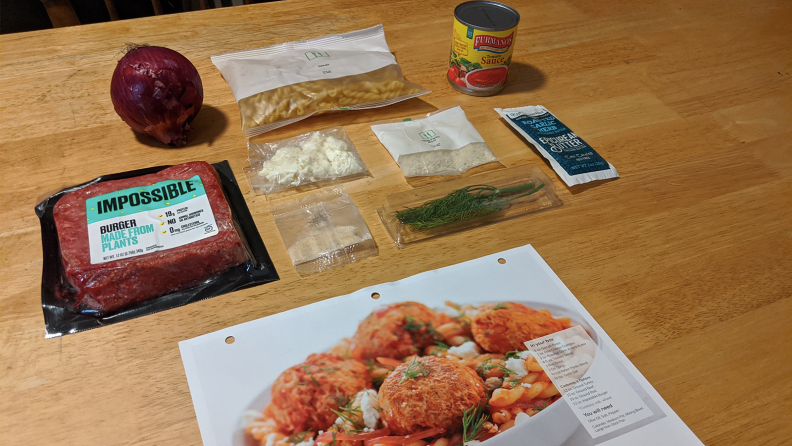 Ingredients for pasta dish including Impossible Burger, red onion, and feta cheese