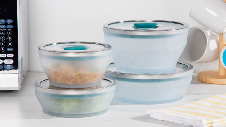 Anyday microwave cookware with lids stacked on top of each other on marble surface.