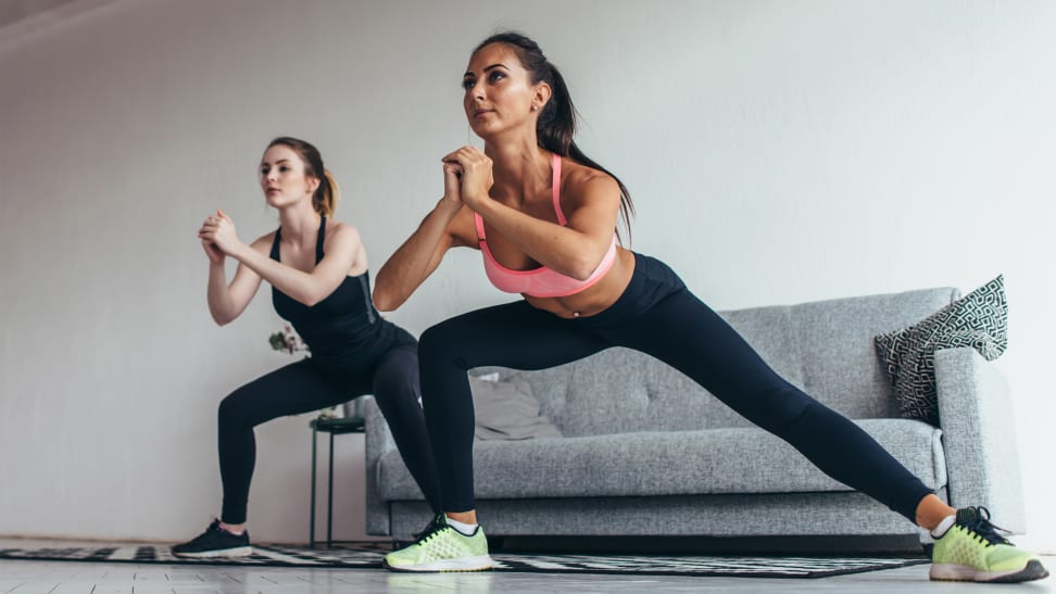 Two women doing side lunges.