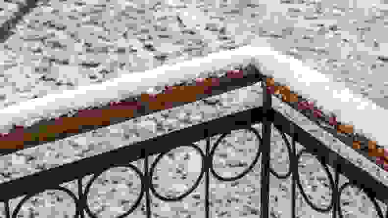 Close up of an outdoor railing dusted in snow.