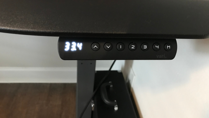 Close up of a raised desk height meter.