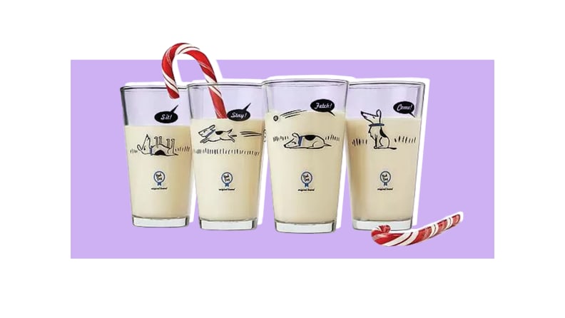 Four glasses depicting various cartoon dogs ignoring commands, full of eggnog with two candy canes. They are all in front of a purple background.