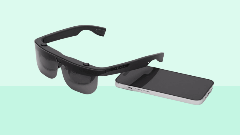 A pair of Eyecane glasses next to a smartphone.