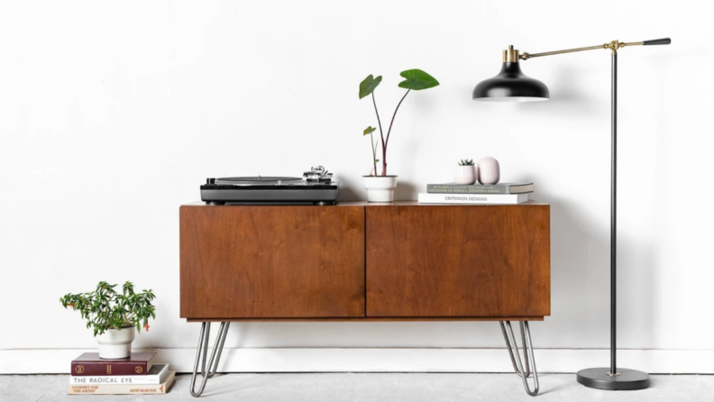 Credenza table with hair pin legs next to a lamp and a plant