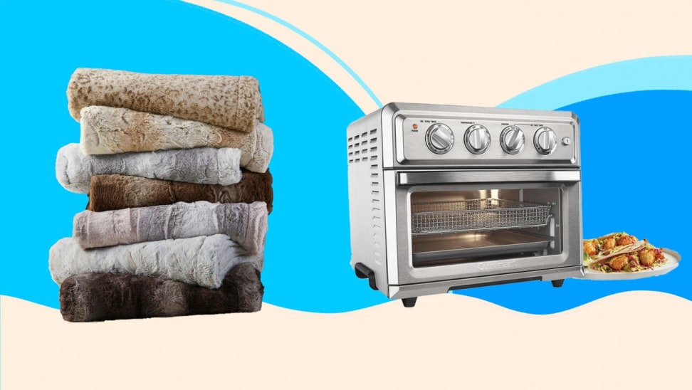 A stack of towels and a stainless steel toaster oven against a blue background.