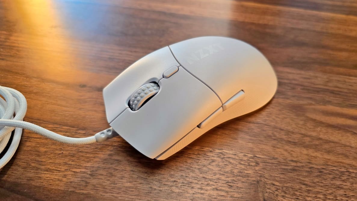 The NZXT Lift 2 Symm mouse on a wood table.