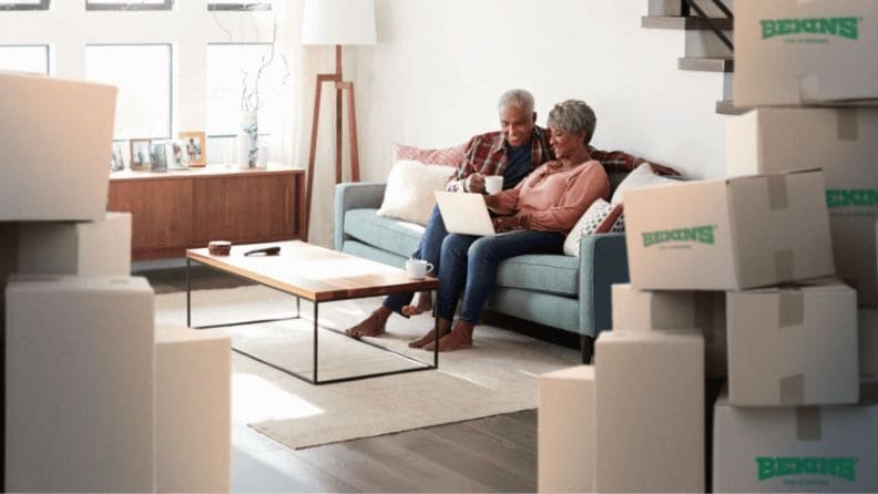 Senior couple relaxing on a couch after moving into a new house