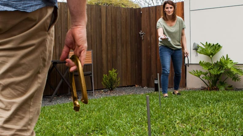 People play horseshoes outsides.