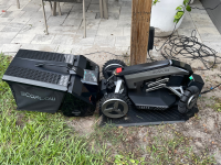EcoFlow Blade Robotic Lawn Mower outdoors on grassy lawn next to patio.