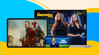 An iPad with a promotional still of the film "Finch" depicting Tom Hanks and a robot in a post-apocalytic environment, an iPhone with a promotional still of "Ted Lasso" with the title character in a soccer stadium, and a MacBook Pro with a promotional still of "The Morning Show" featuring Jennifer Aniston and Reese Witherspoon, all against a light blue, dark blue, yellow, and beige background.