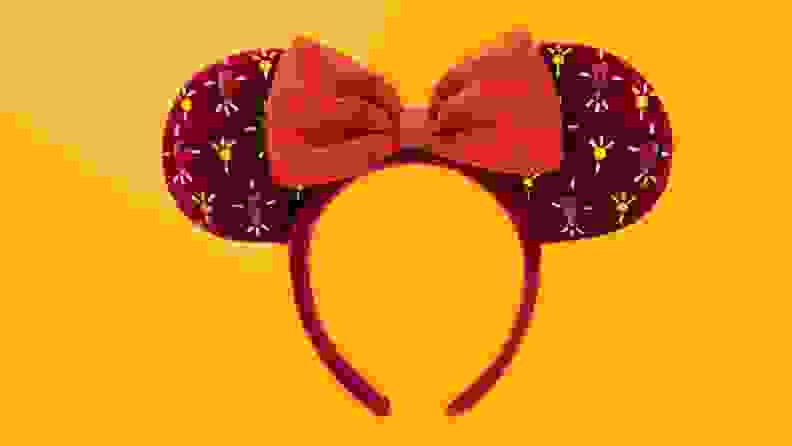 An image of red sequined Mickey Mouse ears on a yellow background.