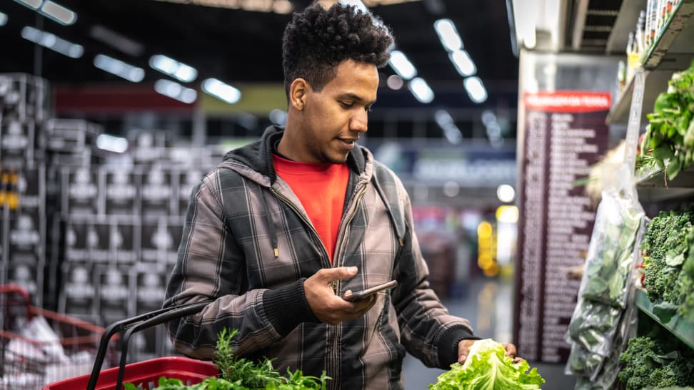 A man peruses the produce section at a supermarket.