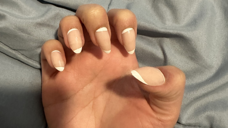 Close-up of a had holding up nails by Glamnetic.