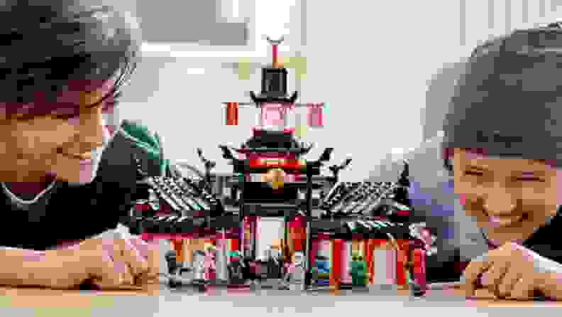 The Lego Ninjago tea house and monastery with two children playing with it