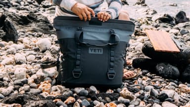 A camper grabbing a drink out of his YETI cooler.