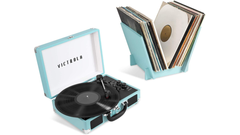 A turquoise suitcase record player with a rack of vinyl LPs.